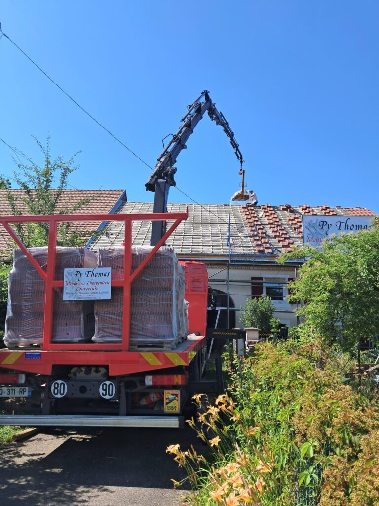 PY Thomas - camion de Py Thomas portant des tuiles avec bras de levage jusqu'au toit